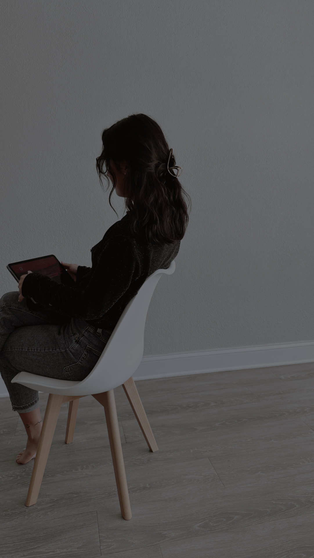 A person seated quietly, reading on a tablet